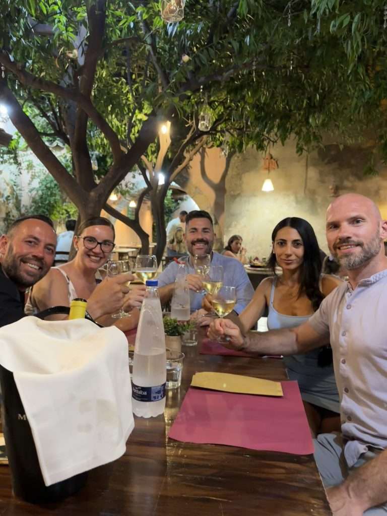 Living a Strong, Calm, and Deeply Alive Life 2 Holistic Fitness Couple Ketty & Markus eating out with friends in Noto, Sicily
